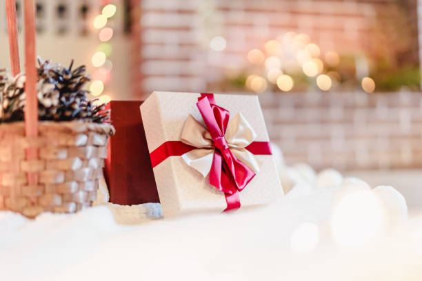 istock Wrapped gift with red ribbon on fireplace background 1072347104