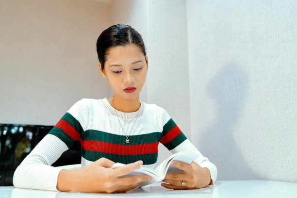 istock Beautiful woman posing - sitting, reading a book, serious 1072347540