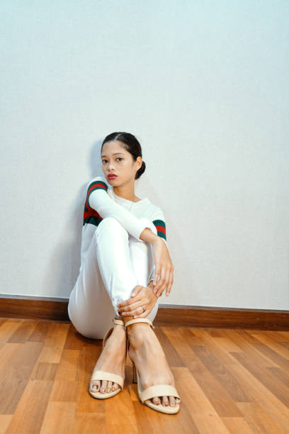 istock Beautiful woman posing -sitting on floor, cross legged, looking at camera 1072347596