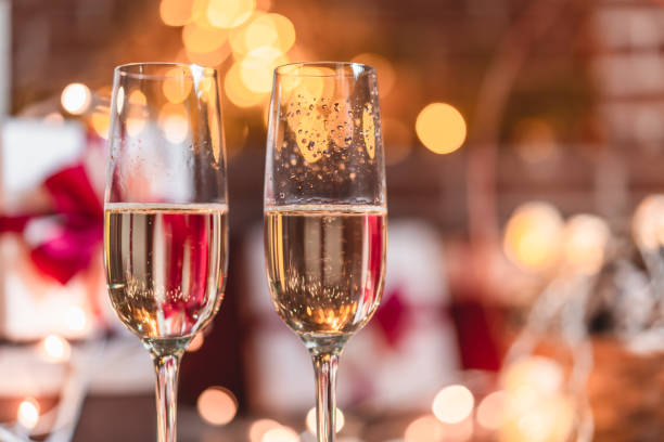 istock Two champagne glasses in front of christmas presents 1072348676