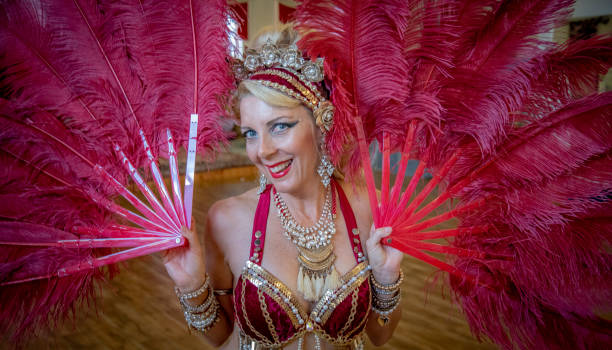 istock Belly dancer rests with red fans on Chaise Lounge. 1072350808