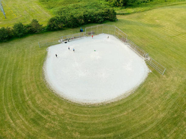 widok z lotu ptaka na pole diamentowe baseball z graczami w letni słoneczny upalny dzień. zielony czysty stadion baseballowy w widoku z lotu ptaka miasta.  kanada, ontario. - baseball baseball diamond grass baseballs zdjęcia i obrazy z banku zdjęć