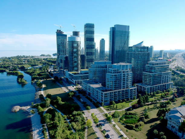 Aerial bird eye shot over Humber Bay Shores Park, Toronto, Canada with coastal condo homes, blue skies, beaches and harbour entrance in view with glass condominiums. Perfect summer day sunset. stock photo