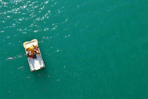 People enjoying a pedal boat trip on the lake of Sainte-Croix,in the Verdon Gorge,southern France.