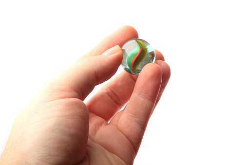 color glass sphere in the human hand isolated on the white background