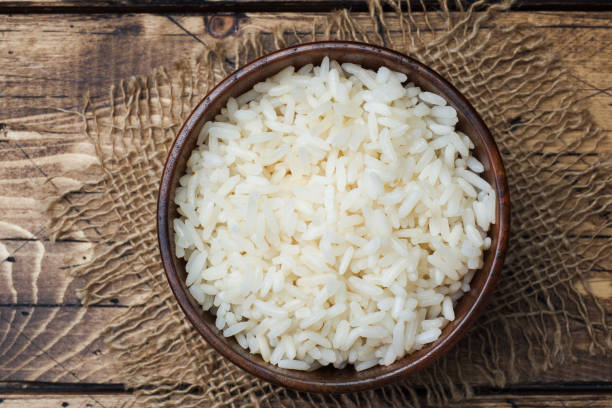 istock White boiled rice in a wooden bowl. Rustic style. 1072370182
