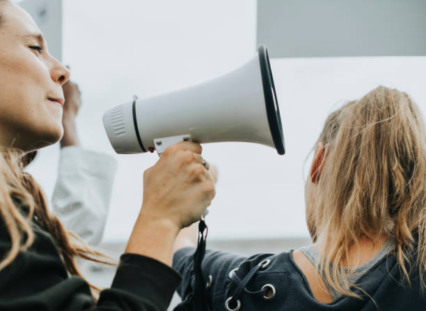 Female activist shouting on a megaphone Female activist shouting on a megaphone activist speech stock pictures, royalty-free photos & images