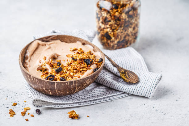 istock Chocolate smoothie bowl with granola in a coconut bowl, copy space. 1072378836
