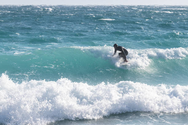 istock Man in wetsuit surfing in cold sea 1072378986