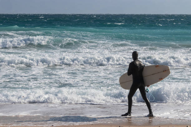 istock Surfer walking on the beach with a surfboard in winter 1072379064