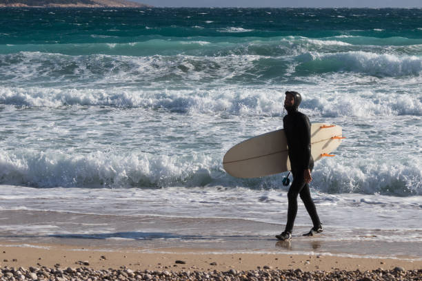 istock Surfer walking on the beach with a surfboard in winter 1072379096