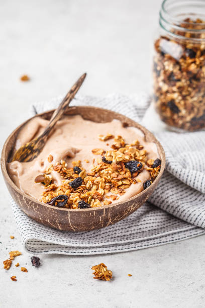 istock Chocolate smoothie bowl with granola in a coconut bowl. 1072379124