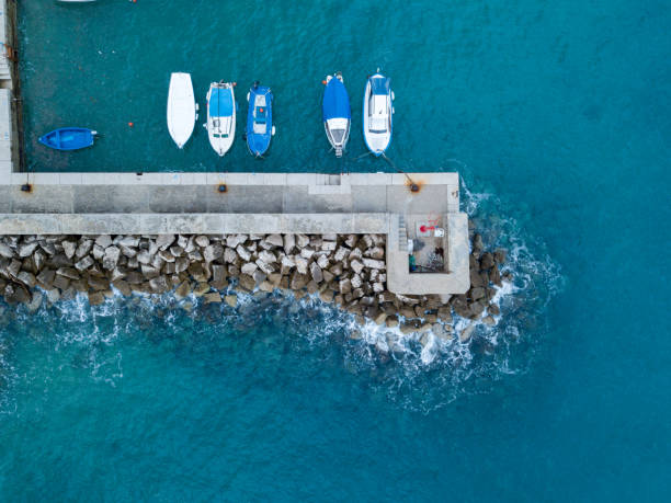 petits bateaux ancrés par la jetée en béton par dessus - safe ride photos et images de collection