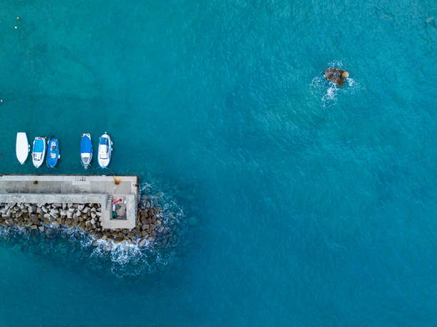 istock Boats next to a pier on blue sea 1072379176