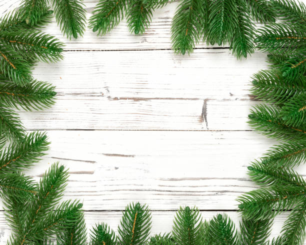 istock Christmas decor with fir branches frame on white wooden board with copy space for text 1072380782