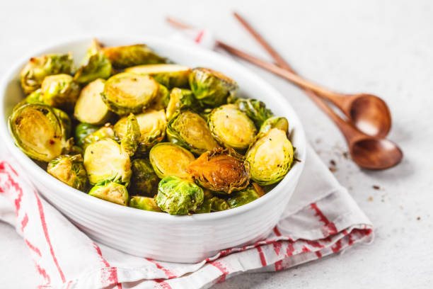 Baked brussels sprouts on a white plate. Baked brussels sprouts on a white plate. Plant based diet concept. brussels sprout stock pictures, royalty-free photos & images