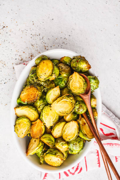 istock Baked brussels sprouts on a white plate, copy space, top view. 1072383772