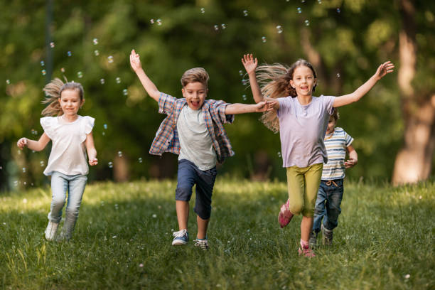 istock Happy kids having fun while running together in springtime. 1072383866