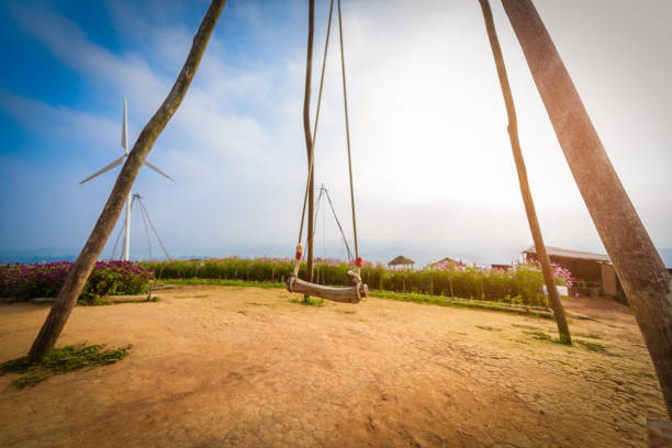 vintage wooden swing with flower garden at view point at Wind turbine field Khao Kho, Petchaboon, Thailand