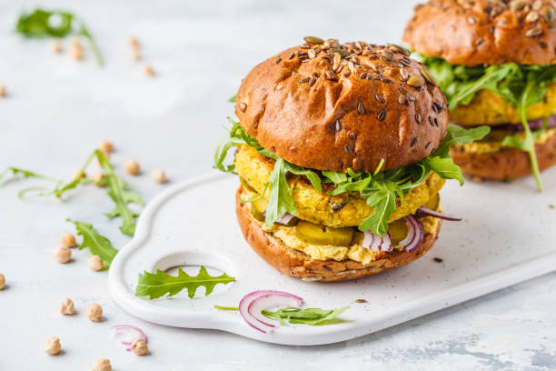 istock Vegan chickpeas burgers with arugula, pickled cucumbers and hummus. 1072389636