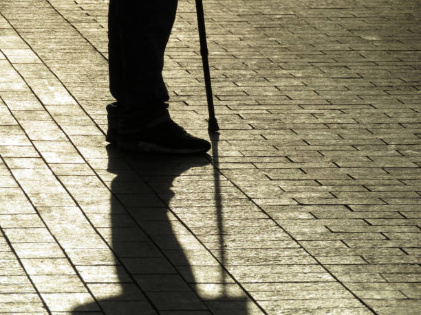 istock Silhouette and shadow of man standing with a cane 1072390212