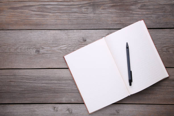 istock Notebook and pen on grey wooden background 1072392354