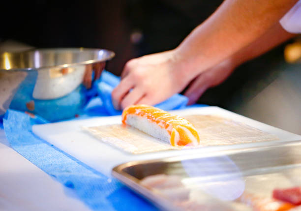 istock chef hands preparing japanese food, chef making sushi, Preparing Sushi roll 1072393468