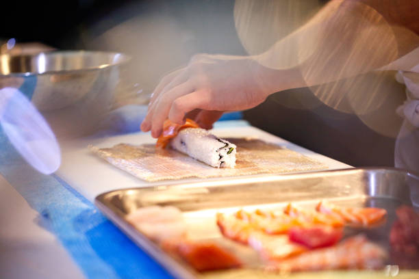 istock chef hands preparing japanese food, chef making sushi, Preparing Sushi roll 1072393470