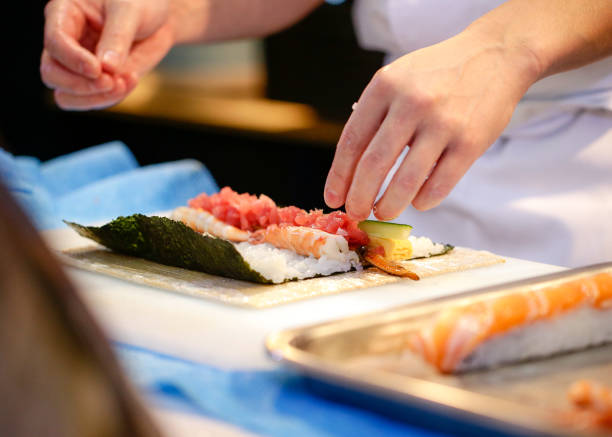 istock chef hands preparing japanese food, chef making sushi, Preparing Sushi roll 1072393478