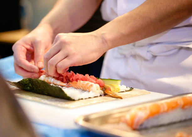 istock chef hands preparing japanese food, chef making sushi, Preparing Sushi roll 1072393482