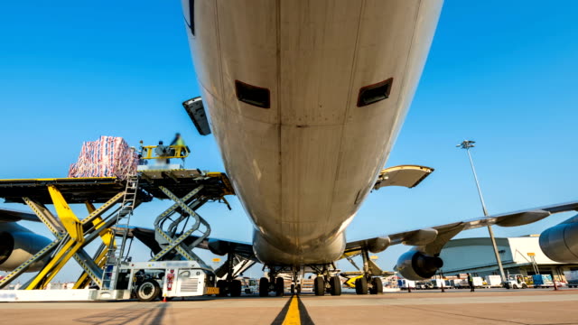Time lapse zoom in loading cargo outside cargo plane