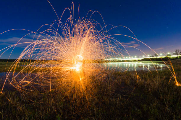 istock Trajectory of burning sparks reflected on the river surface 1072395222
