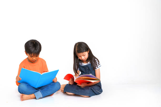 Little boys viewing photobooks with vacations photos. All photos visible are my own copyright. Slightly soft focus.