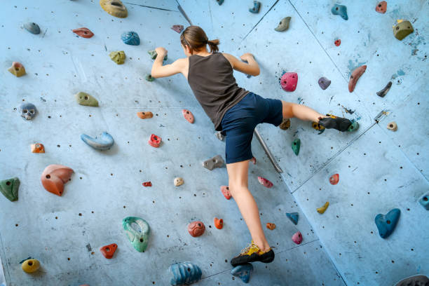 adolescente formação escalada na parede de escalada indoor - climbing wall rock climbing holding reaching - fotografias e filmes do acervo