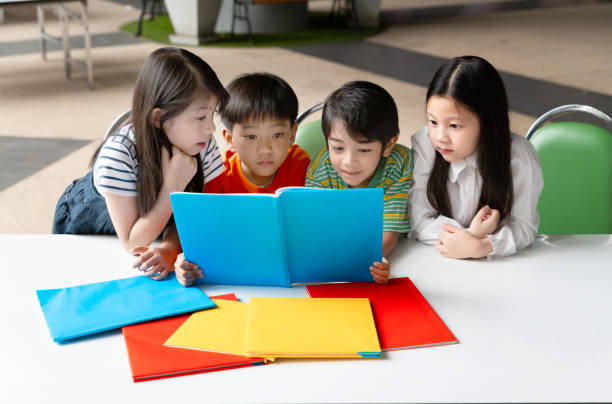 istock Asian Little Children Reading Book Cheerful 1072403808