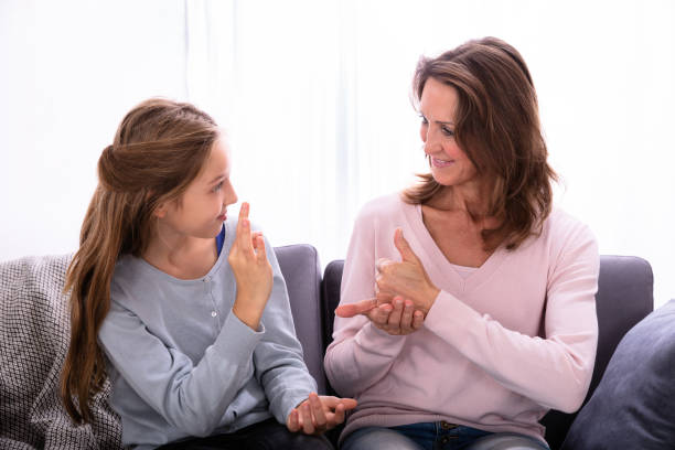 istock Girl Learning Sign Languages From Woman 1072406946