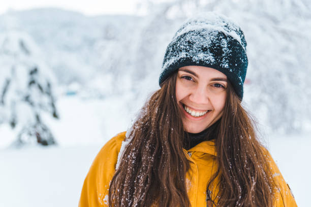 istock smiling woman portrait outdoors snow on hat 1072407466