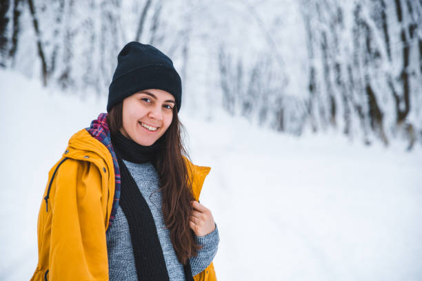 istock smiling woman portrait outdoors snow on hat 1072407508