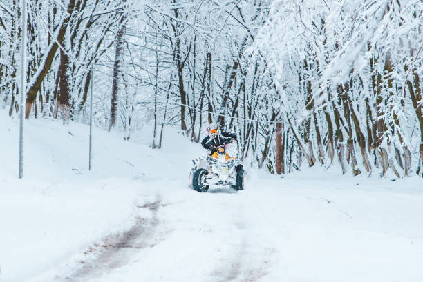 istock two persons ride quad bike in snowed forest 1072407540