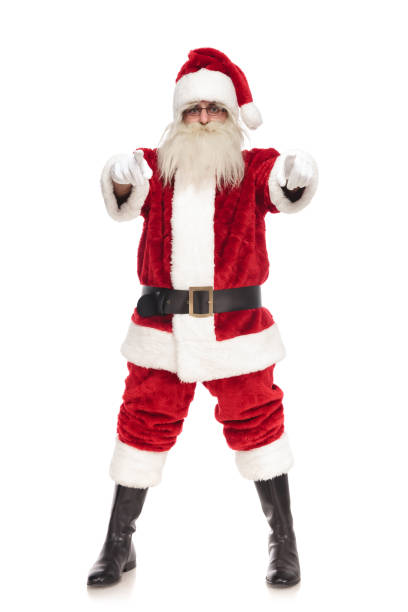 istock merry santa claus pointing fingers while standing with parted feet 1072412818