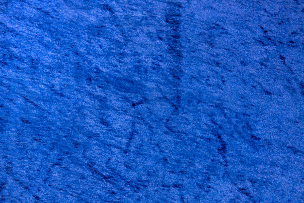 Blue textured fabric with soft patterns and shading. Abstract background for design and print.