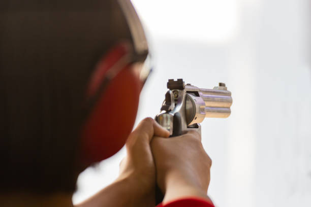 istock Man hold a gun ready to shoot  practicing shooting in the park 1072420522