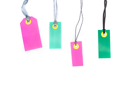 Blank multicolored labels tags made of cardboard or price notes of pink and green color isolated on white background.