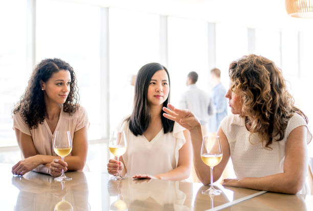 istock Businesswomen with wineglasses discussing at table 1072422232