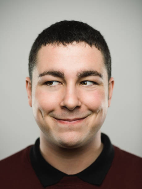 portrait d’un jeune homme caucasien heureux à la recherche de suite. - sourire narquois photos et images de collection