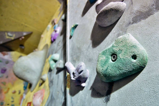 istock Grey wall with climbing holds in gym 1072425860