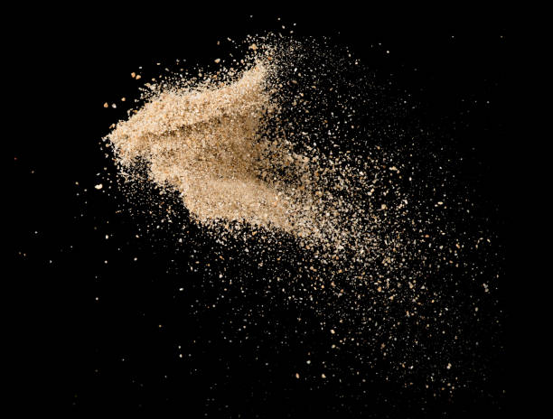 istock Sand flying explosion isolated on black background ,throwing freeze stop motion object design 1072426356