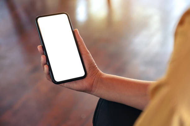 istock Mockup image of a woman's hand holding black mobile phone with blank white desktop screen 1072430182