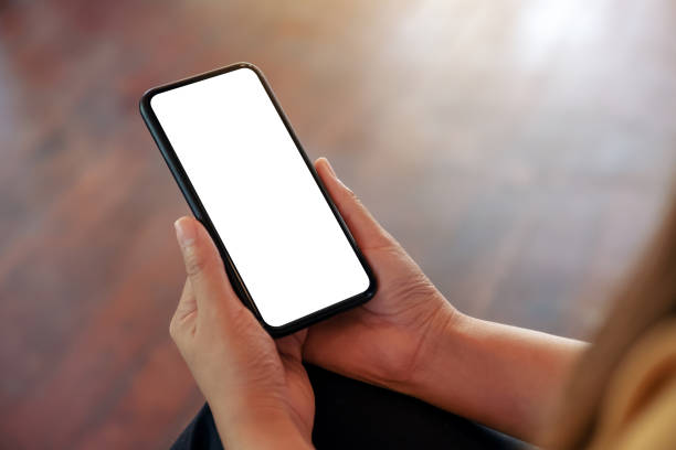 istock Mockup image of a woman's hand holding black mobile phone with blank white desktop screen 1072430200