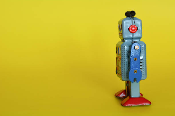 istock Vintage tin toy robot isolated on a yellow background. 1072433200